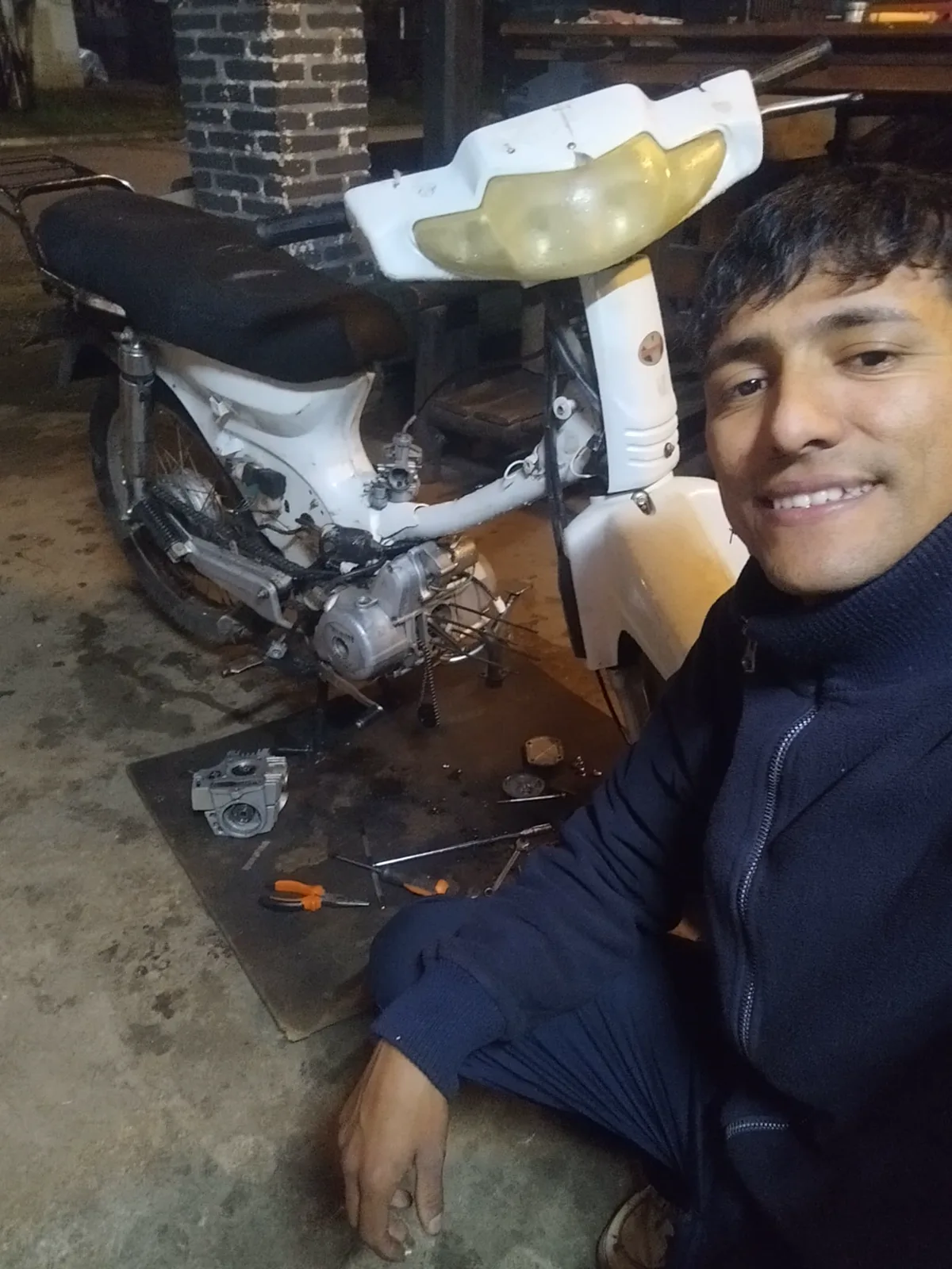 Mecánico de Mecánica Neco junto a una moto desarmada durante el trabajo