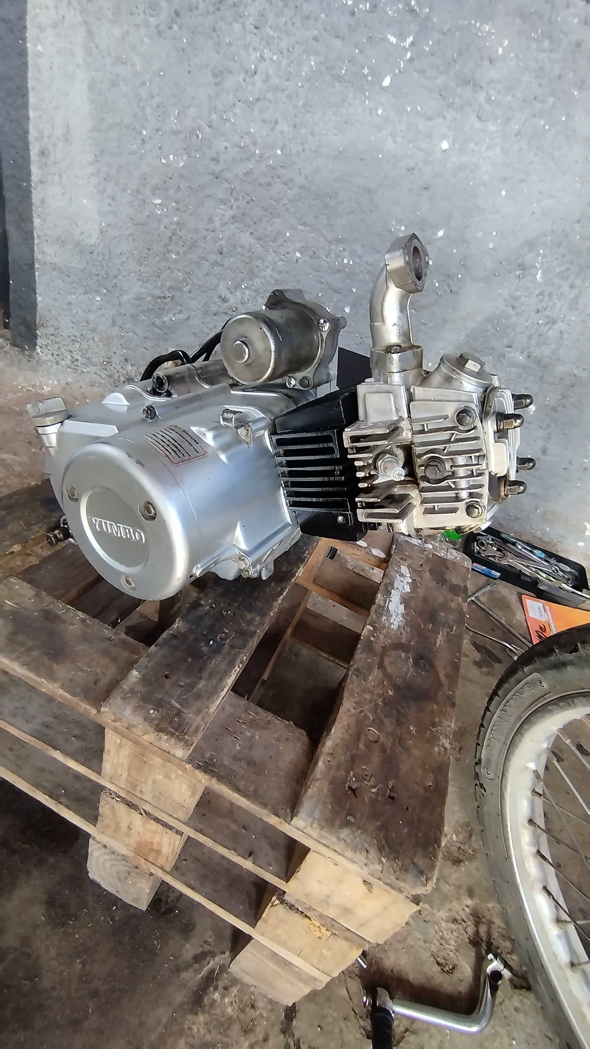 Motor Yumbo retirado de la moto y apoyado en el banco durante una reparación